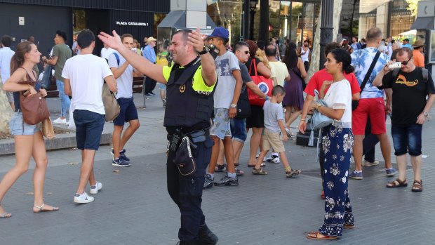 Police officers tell members of the public to leave the scene in a street in Barcelona on Thursday.