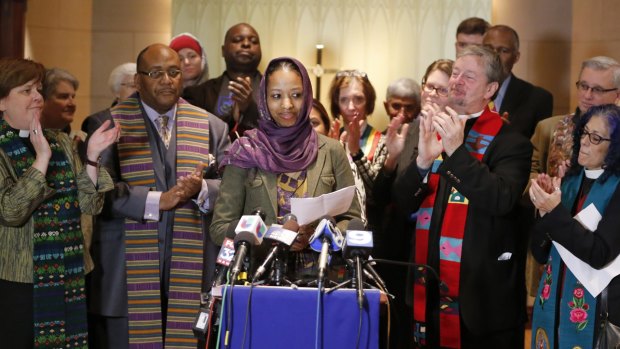 Larycia Hawkins, centre, a professor at  Wheaton College, is greeted with applause from supporters at a news conference on December 16 after being placed on leave. Dr Hawkins, a Christian teaching political science at the private evangelical school west of Chicago,  began wearing a hijab to counter what she called the "vitriolic" rhetoric against Muslims in recent weeks. 