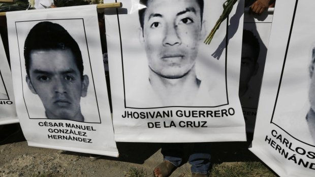 Sorely missed: Relatives of the missing students carry their photographs at a march in Iguala in south-west Mexico.
