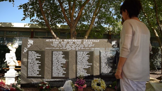 A woman looks at the Granville train disaster memorial that names the 83 people who died 40 years ago.