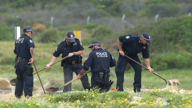 Police dig in the sand where the baby was found.
