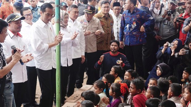 Indonesian President Joko Widodo speaks to residents outside a collapsed Atta Karuf mosque following this week's earthquake in Aceh.