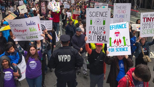 Demonstrators pass a policeman in the March for Science in New York last week.
