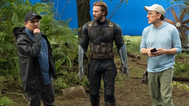 Infinity War directors Joe Russo (left) and Anthony Russo (right) on set with Captain America (Chris Evans).