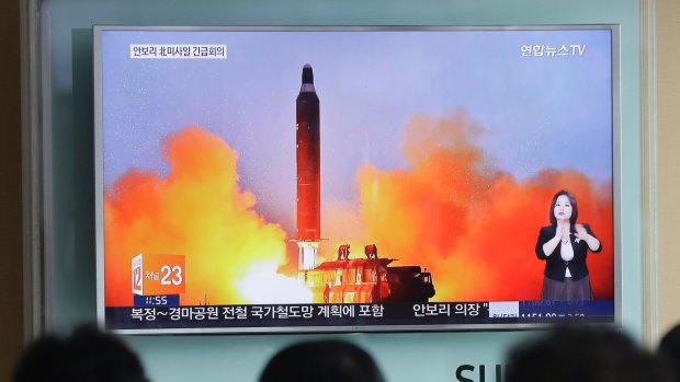 People watch a TV news channel airing an image of North Korea's ballistic missile launch published on Thursday in North Korea's Rodong Sinmun newspaper.