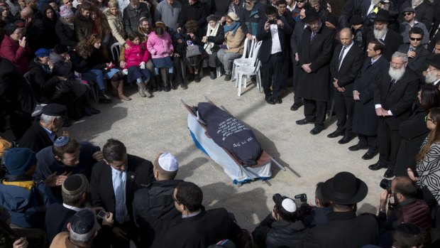 Wave of violence: Family and friends of Israeli woman Dafna Meir attend her funeral in a cemetery last Monday.