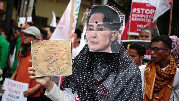 A Muslim woman wears a mask of Myanmar's Foreign Minister Aung San Suu Kyi during a rally against the persecution of Rohingya Muslims last month.