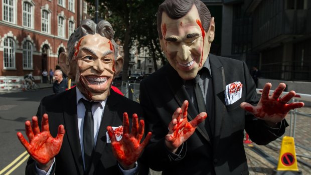Demonstrators dressed as former British prime minister Tony Blair and former US president George Bush Jr outside the Queen Elizabeth II conference centre in London.