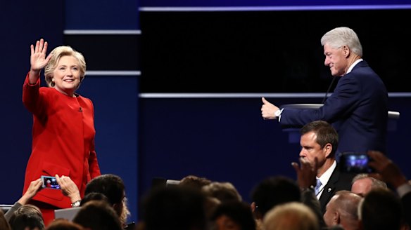 Hillary Clinton, 2016 Democratic presidential nominee, left, waves as former US president Bill Clinton gestures during the first US presidential debate.
