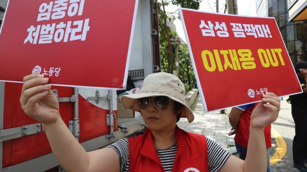 A protester outside the court in Seoul demonstrates against the Samsung executives.