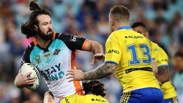Aaron Woods of the Tigers is tackled by the Eels defence during the round 20 NRL match between the Wests Tigers and the Parramatta Eels at ANZ Stadium.