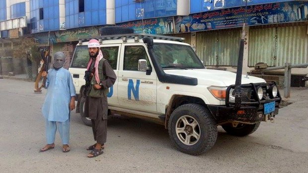 Unrest: Taliban fighters with a seized UN vehicle in Kunduz.