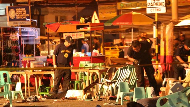 Police officers at the scene of an explosion at a night market in Davao city on Friday night.