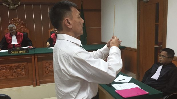 Lim Jit Wee takes an oath before testifying in West Jakarta District Court that he didn't know Christian at the time of his arrest. 