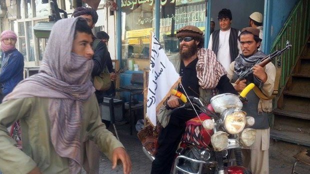 A Taliban fighter sits on his motorcycle adorned with a Taliban flag in a street in Kunduz, Afghanistan, in September.