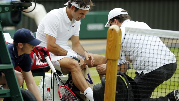 Injury trouble: Federer receives attention during his Wimbledon semi-final against Milos Raonic