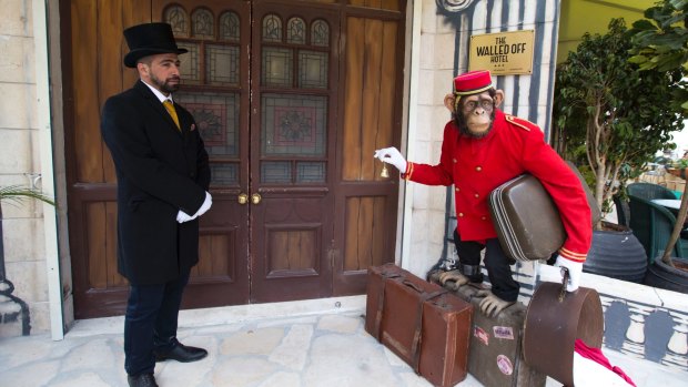 Doorman stands at the entrance of the "The Walled Off Hotel".