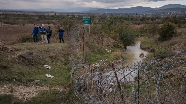A European Union monitoring mission walks along razor wire set up within Georgia by South Ossetian authorities.