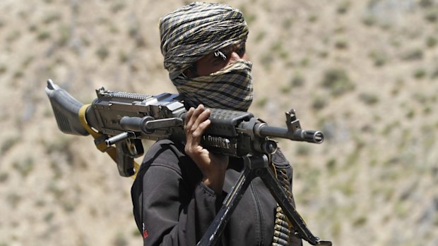 A member of a breakaway faction of the Taliban fighters guards a gathering in Shindand district of Herat province, Afghanistan. 