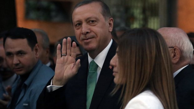 Turkey's President Recep Tayyip Erdogan salutes as he arrives at the parliament in Ankara, a day after Turkish lawmakers approved a three-month state of emergency that allows the government to extend detention times and issue decrees without parliamentary approval. 