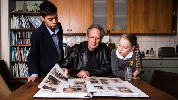 Holocaust survivor Peter Halas shows (L-R) Alex Tofler and Lily Shrire a photo album of his family that were affected by the holocaust. 
