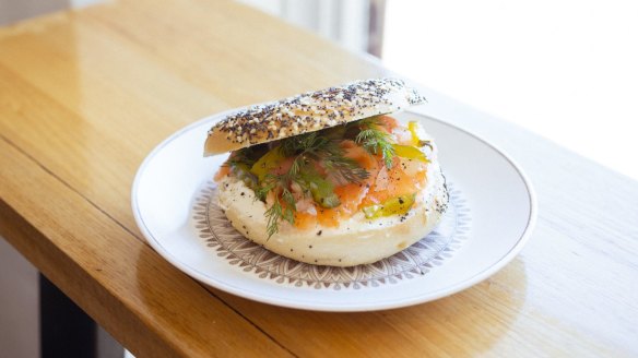A smoked salmon bagel with cream cheese, dill and pickled onion.