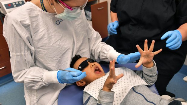 Oral health therapist Kimberley Karp helps a young patient deal with some nerves at the Royal Dental Hospital.