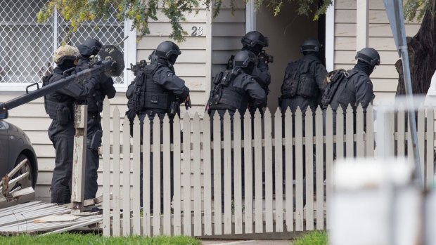 Heavily armed police broke down the door of the house.
