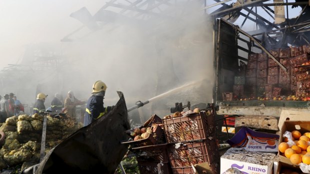 Firefighters spray water at the site of a truck bomb attack at a crowded market in Baghdad two days ago.