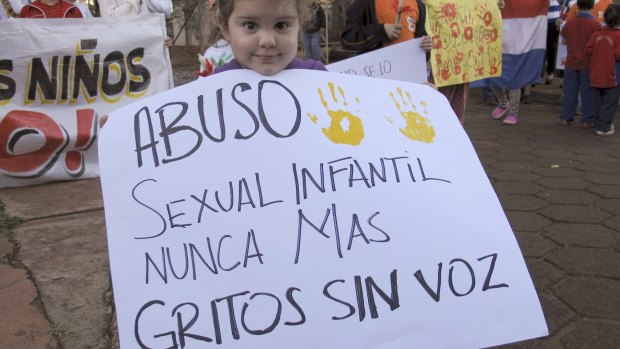 A child holds a sign that reads in Spanish "Sexual child abuse never again, screams without voice," in a protest in Paraguay in May.