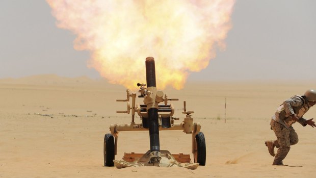 A Saudi soldier fires a mortar towards Houthi movement position, at the Saudi border with Yemen.