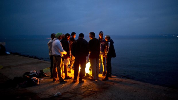 Afghan refugees gather around a fire after arriving on the Greek island of Lesbos from the Turkish coast.