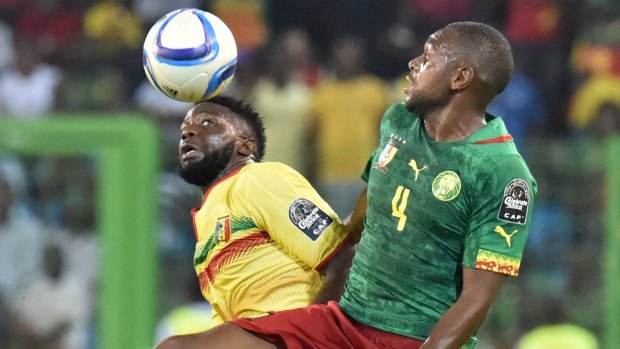 Mali's midfielder Bakary Sako (left) heads the ball from Cameroon's midfielder Raoul Cedric Loe. 