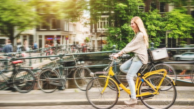 A woman cycling through the Jordaan district. Amsterdam is a city where, for once, cyclists really do own the road.