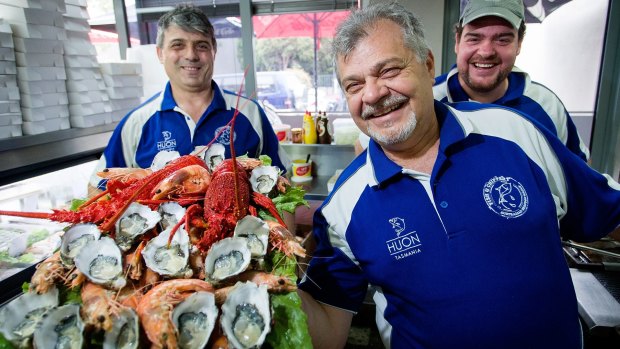 Kosta Tsapogas (left), Con Patsiotis and his son Theodore (right) show off a platter of premium Australian seafood at the Australian Seafood Fish and Chippery in North Coburg.