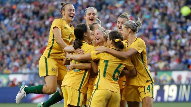 Australian players celebrate as they surround Tameka Butt, goalscorer against the US at the Tournament of Nations.
