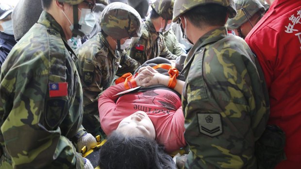 A woman is carried from the collapsed building in Tainan.
