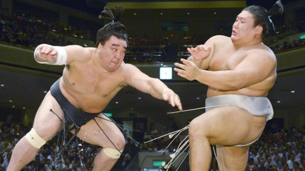 Mongolian sumo grand champion Harumafuji, left, pushes opponent Takanoiwa out of the ring to win their bout at the Autumn Grand Sumo Tournament in Tokyo in 2016.