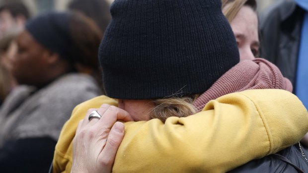 People hug in the street in front  of the Carillon cafe and the Petit Cambodge restaurant  in Paris on Saturday, a day after more than  120 people were killed  in a series of terror attacks. 