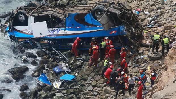Firemen recover bodies from a bus that fell off a cliff in Peru after it was hit by a tractor-trailer rig.