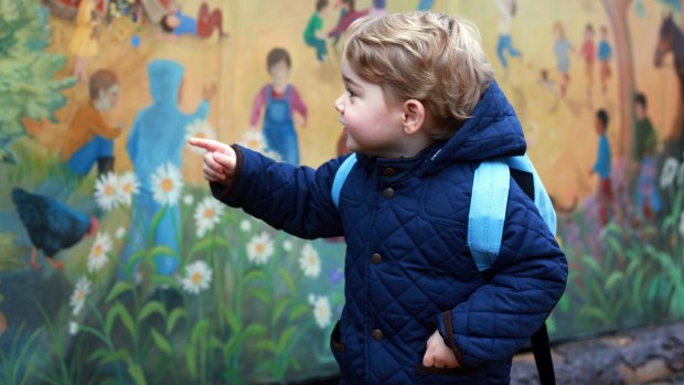 Prince George turns to look at a colourful mural on a wall at his new nursery school.