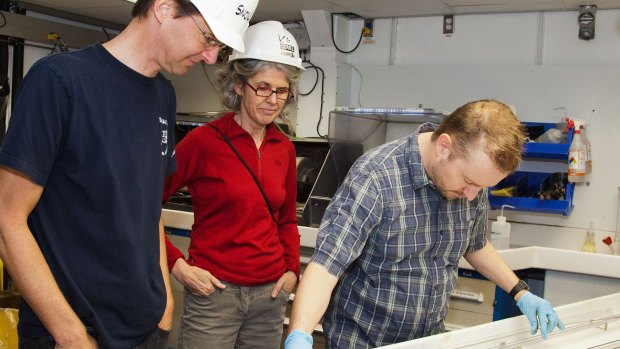 Scientists inspect cores samples taken aboard the drill ship.