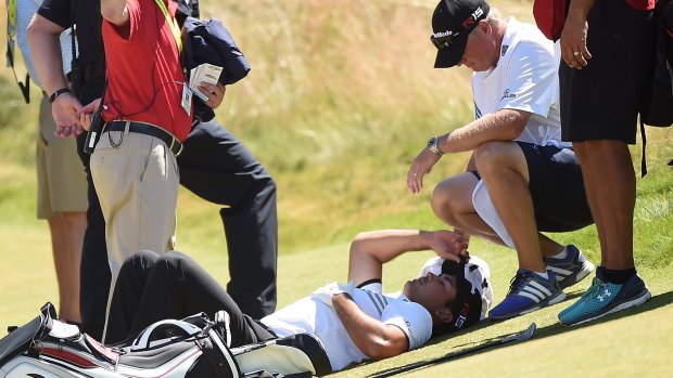 Challenges: Jason Day is tended to by his caddie as he lies on the ninth green after a dizzy spell at the 2015 US Open.