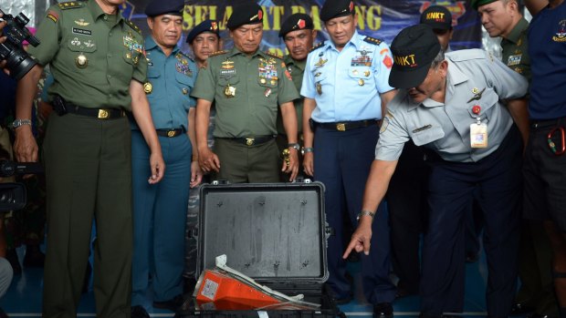 Tatang Kurniadi (right), from The National Transportation Safety Committee, examines the Flight Data Recorder in Pangkalan Bun after it was retrieved from the Java Sea.