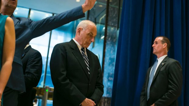John Kelly, the White House chief of staff, looks down as US President Donald Trump speaks in the lobby of Trump Tower.