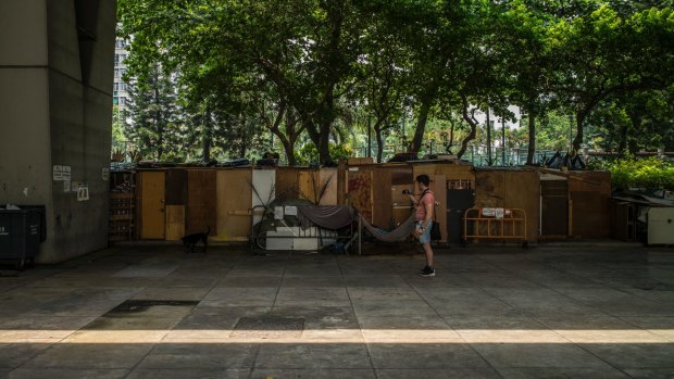 A tourist takes photos of makeshift homeless shelters, while on a tour with Alla Lau from Hong Kong Free Tours.