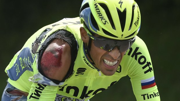 Spain's Alberto Contador grimaces as he rides to catch up with the pack after crashing during the first stage of the Tour de France.