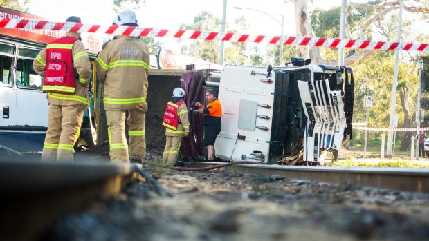 Fire crews contain the risk of fire at the scene of a collision between a tram and a truck in Parkville.