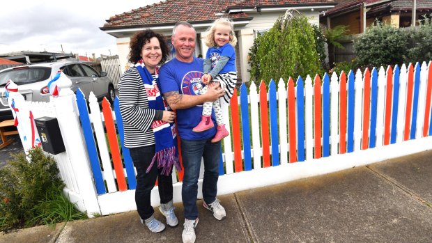 Footscray locals Col Kelly, Karen Cook and Eloise, 3, show their true footy colours. 