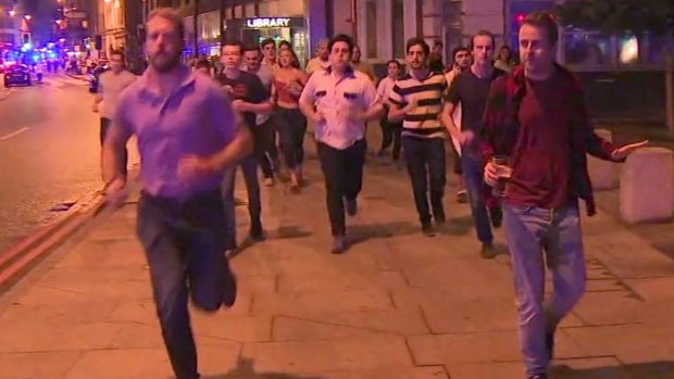 A man holds his beer while people flee terror attacks in London on Saturday. 